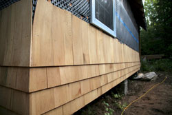 cedar siding with shingles; the first three courses from the ground